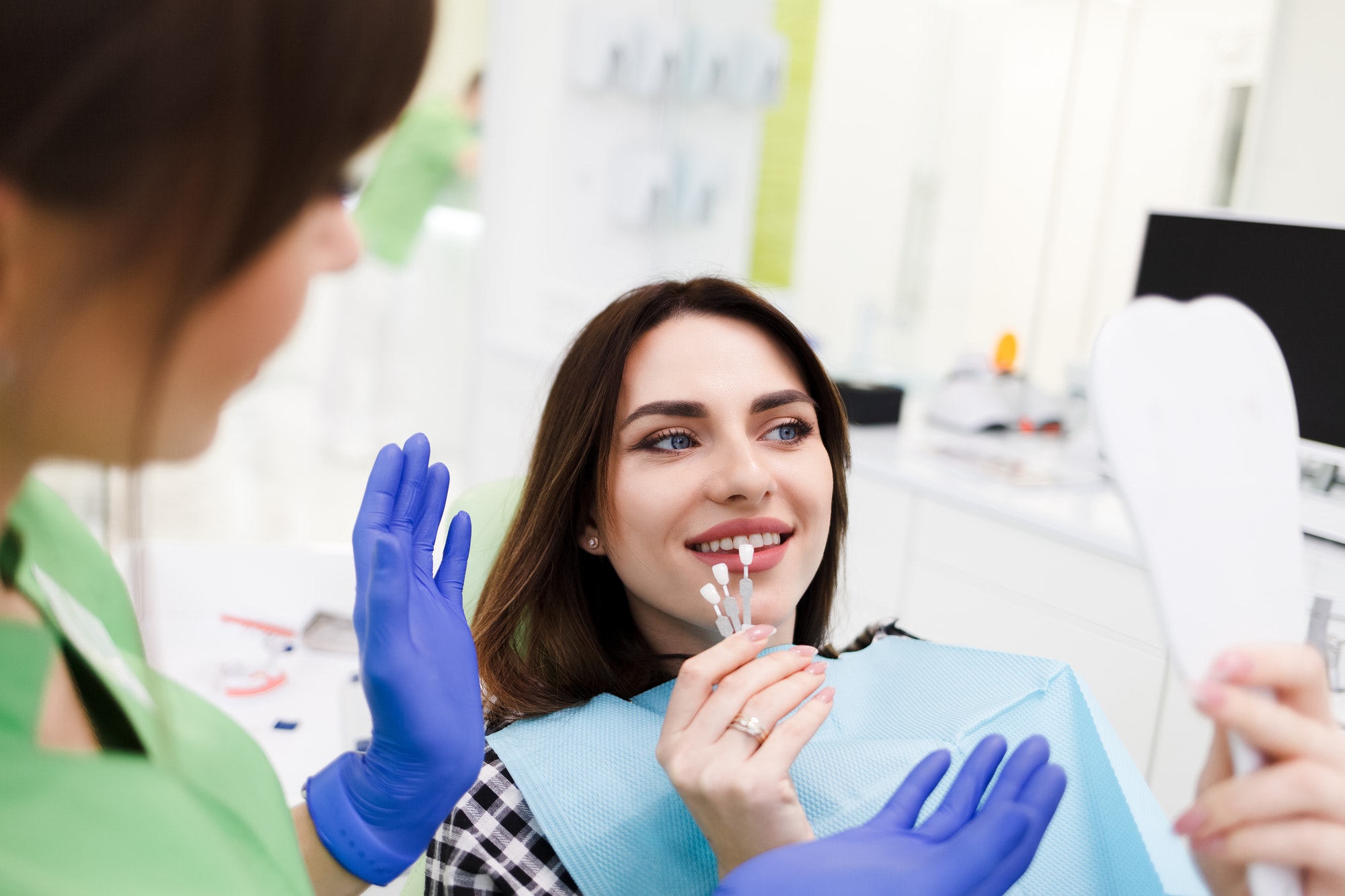 Girl chooses color of veneers at the dentist office